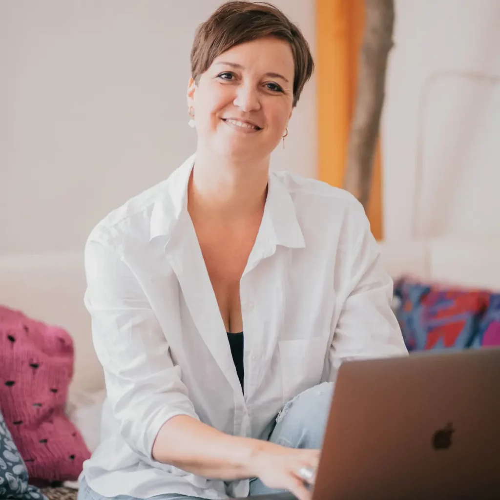 steffi lächelt in die kamera und tippt in ihren laptop