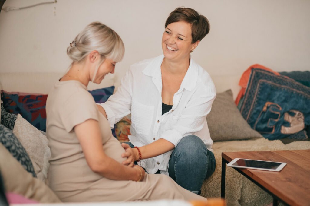 Mamacoach hält Schwangere den Babybauch